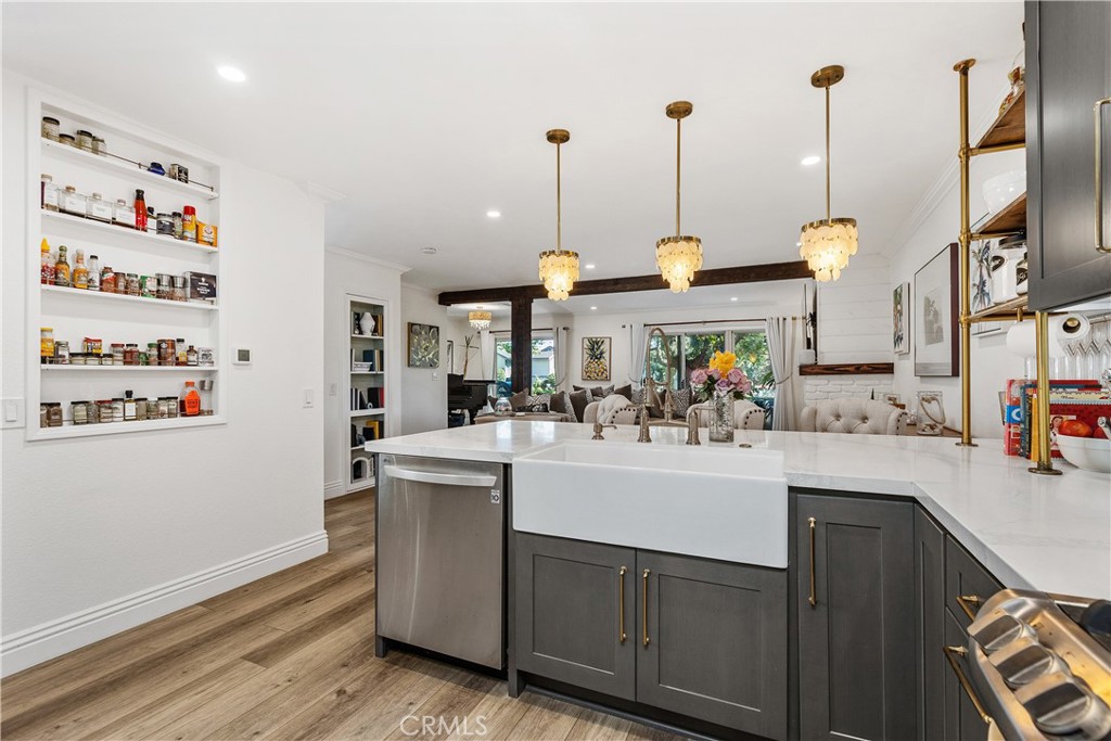 Remodeled kitchen with farmhouse sink and quartz counters