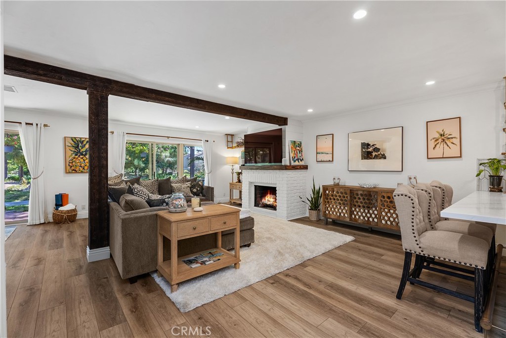 Open living and dining room with fireplace and exposed beam at 26972 Mill Pond Road #30
